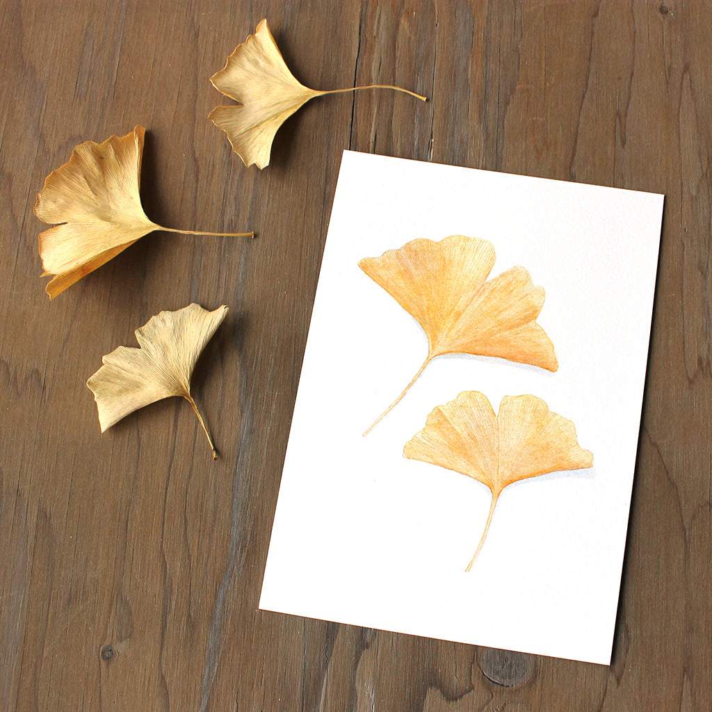 Art print of an fall watercolor painting of two golden yellow ginkgo leaves. Artist Kathleen Maunder