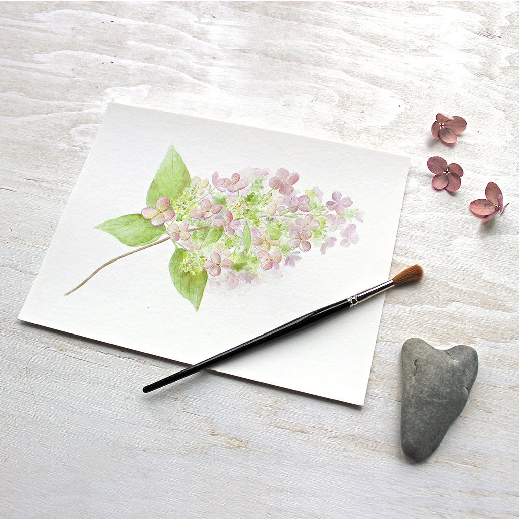 An art print featuring a lovely watercolor painting of a small branch of delicate pink and green hydrangea. Artist Kathleen Maunder.