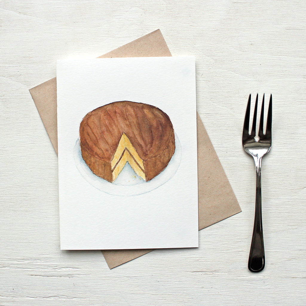 Note card featuring a watercolour painting of a vanilla and chocolate layer cake. Artist Kathleen Maunder.