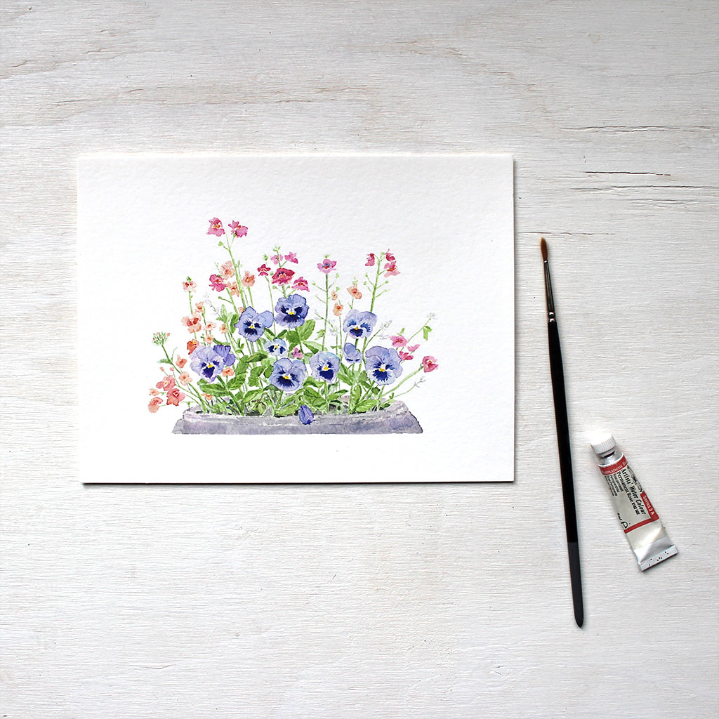 A print of a watercolor painting depicting a flower pot containing blue pansies, pink nemesia, coral diascia and white euphorbia. Artist Kathleen Maunder.