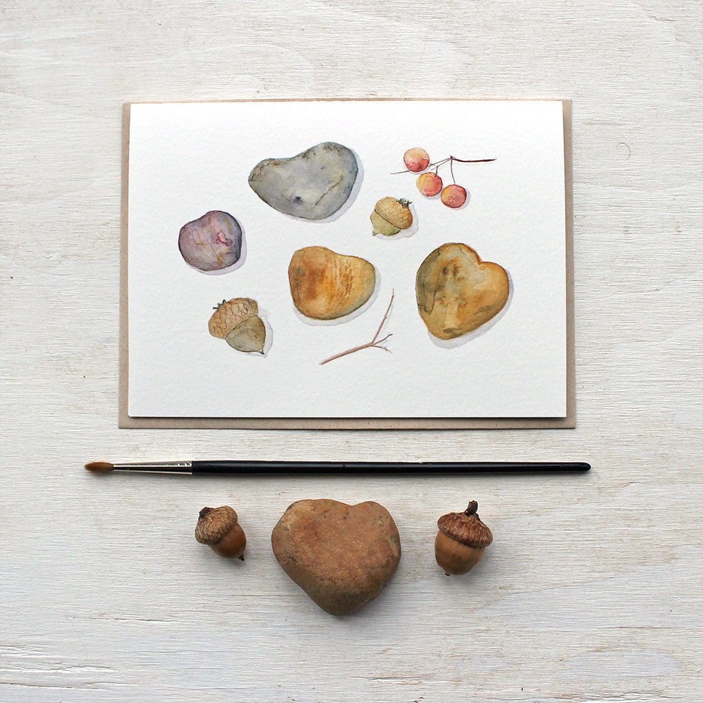 A lovely set of five note cards featuring a watercolor painting of heart-shaped stones, acorns and cranberries to create an autumn nature collection. Artist Kathleen Maunder