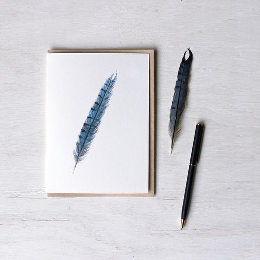Note card with Kraft envelope. Watercolour painting of blue jay feather by artist Kathleen Maunder.