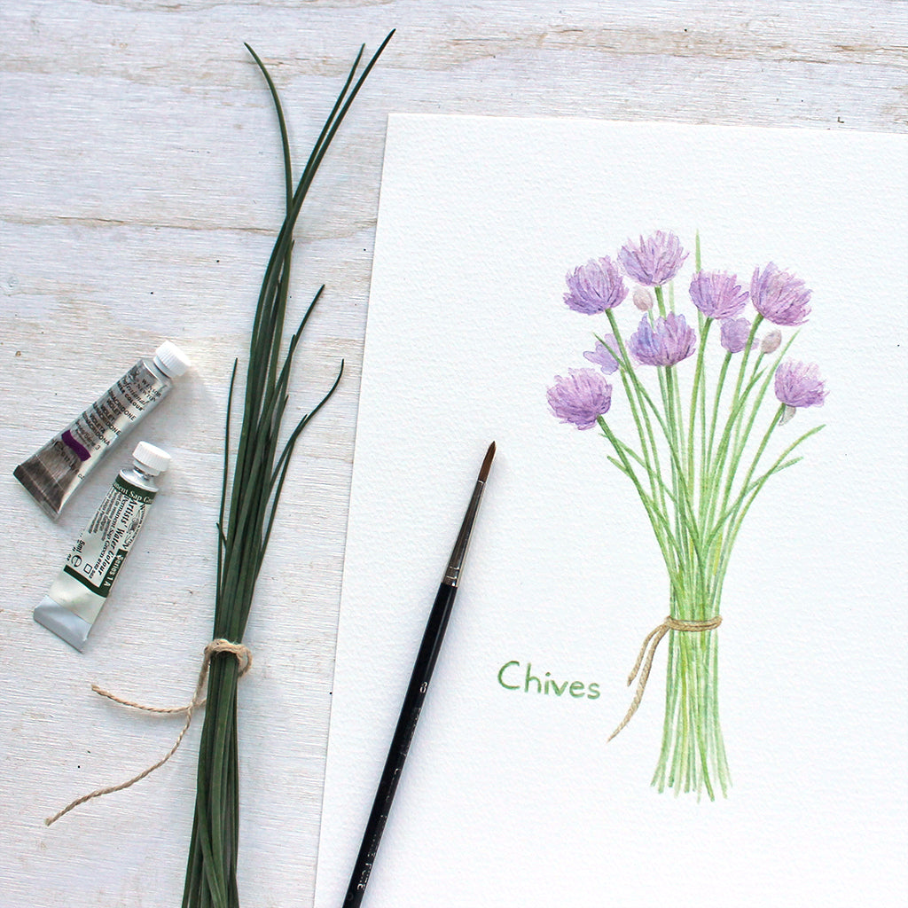 Close up of a reproduction of a watercolor painting of a bunch of purple chives tied with string by Kathleen Maunder, Trowel and Paintbrush