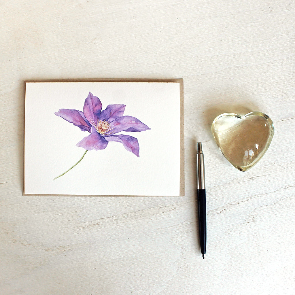 Purple clematis flower watercolour painting on a note card. Artist Kathleen Maunder.