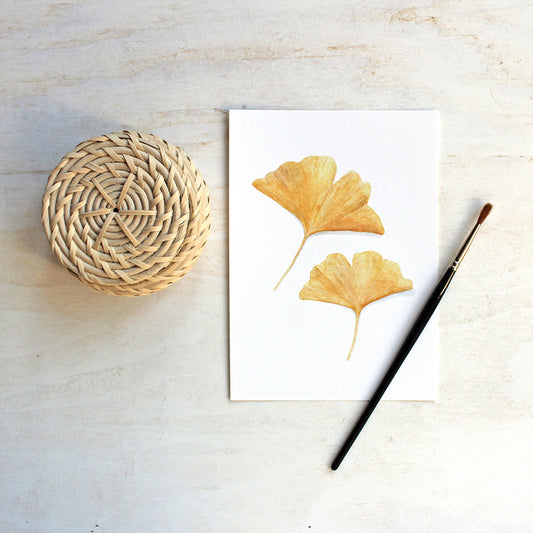 Art print of an autumn watercolor painting of two yellow ginkgo leaves. Artist Kathleen Maunder