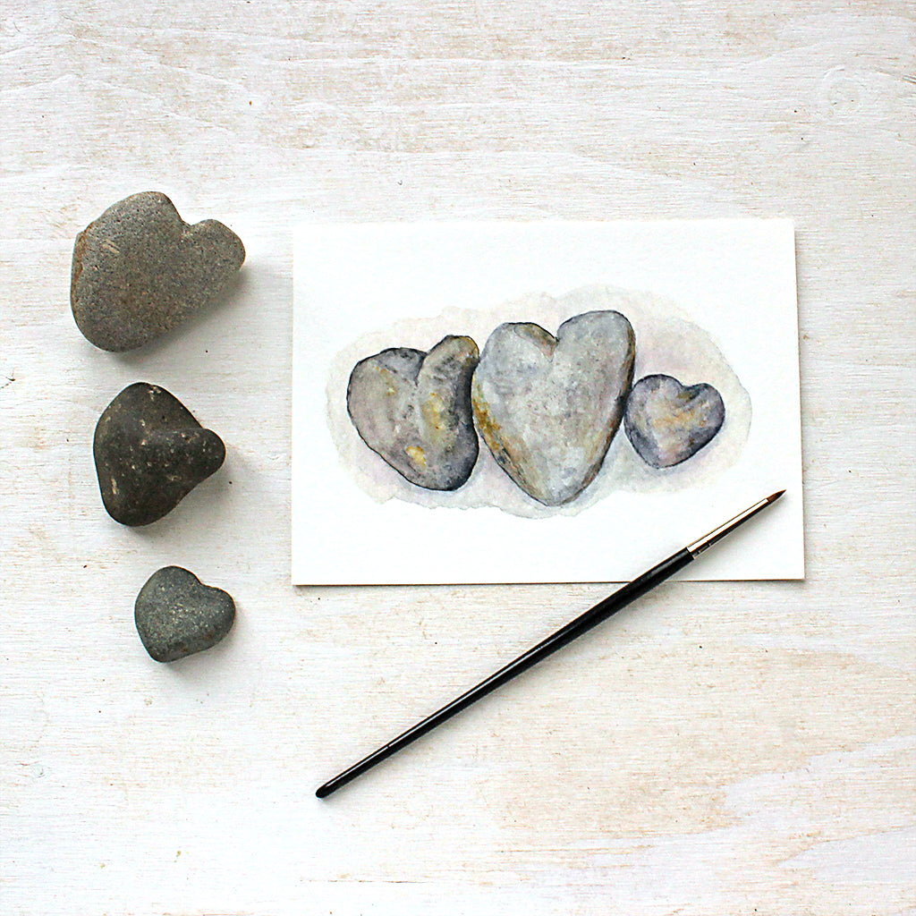Watercolor painting of three beautiful heart-shaped beach rocks found in Ogunquit, Maine. Artist Kathleen Maunder