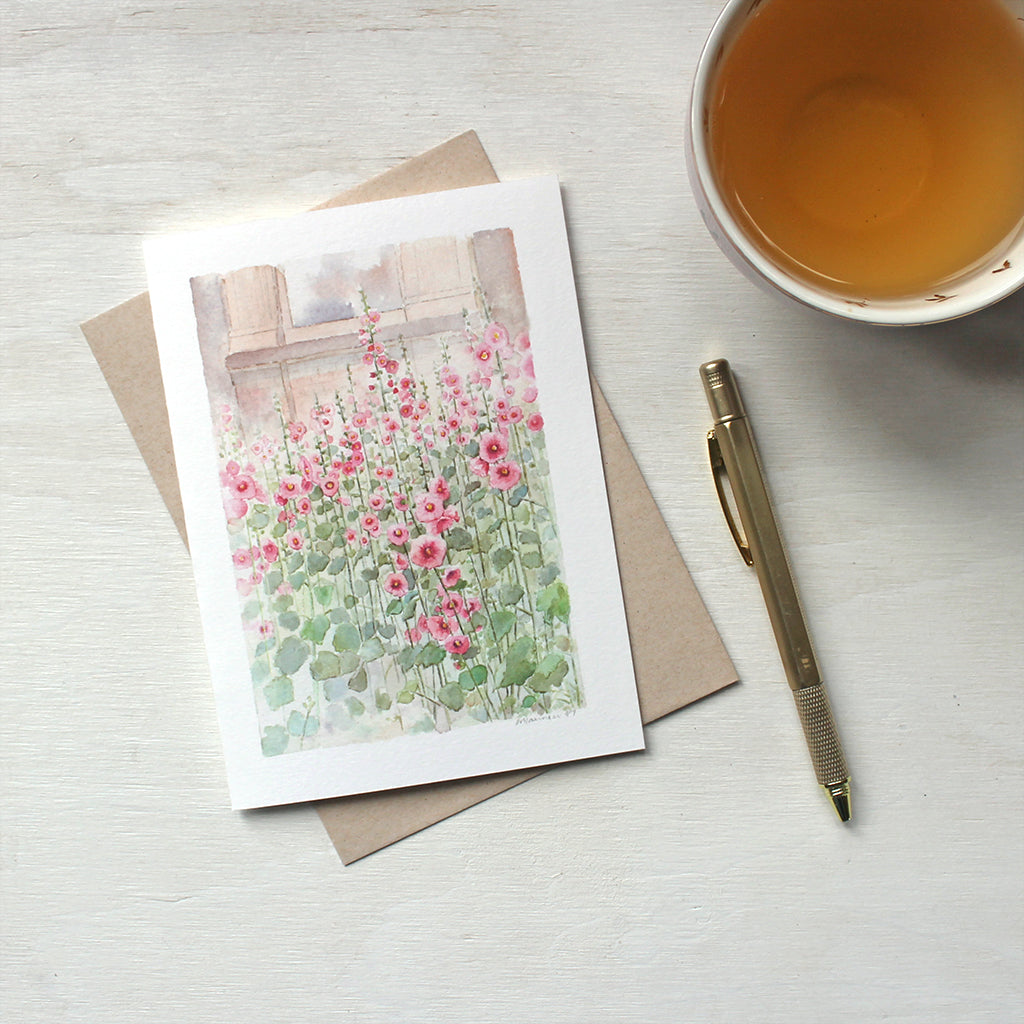 Note card featuring a watercolor painting of pink hollyhocks. Artist Kathleen Maunder.