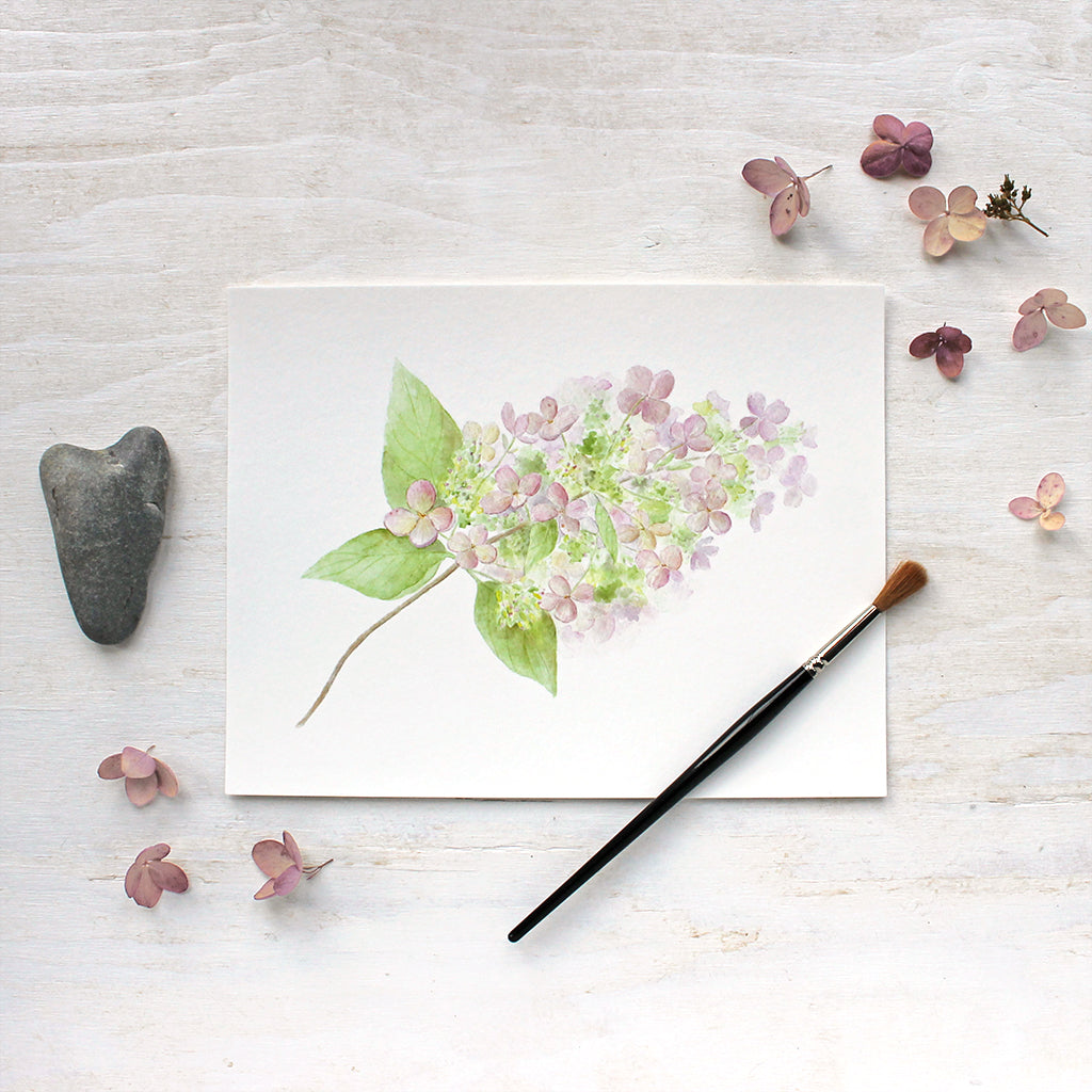 An art print featuring a lovely watercolor painting of a small branch of delicate pink and green hydrangea. Artist Kathleen Maunder.