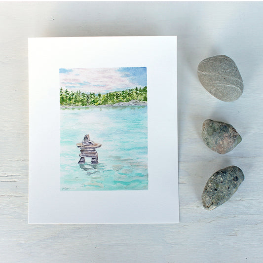 Art print featuring a watercolor painting of a lake and inuksuk. Artist Kathleen Maunder.