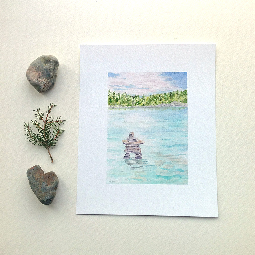 Art print featuring a watercolor painting of a lake and inuksuk. Artist Kathleen Maunder.