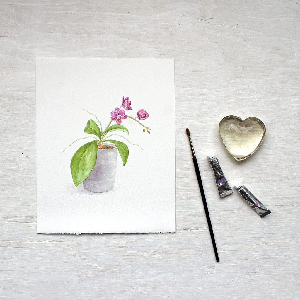 Print of watercolor painting depicting a little orchid plant in a pot. Artist Kathleen Maunder