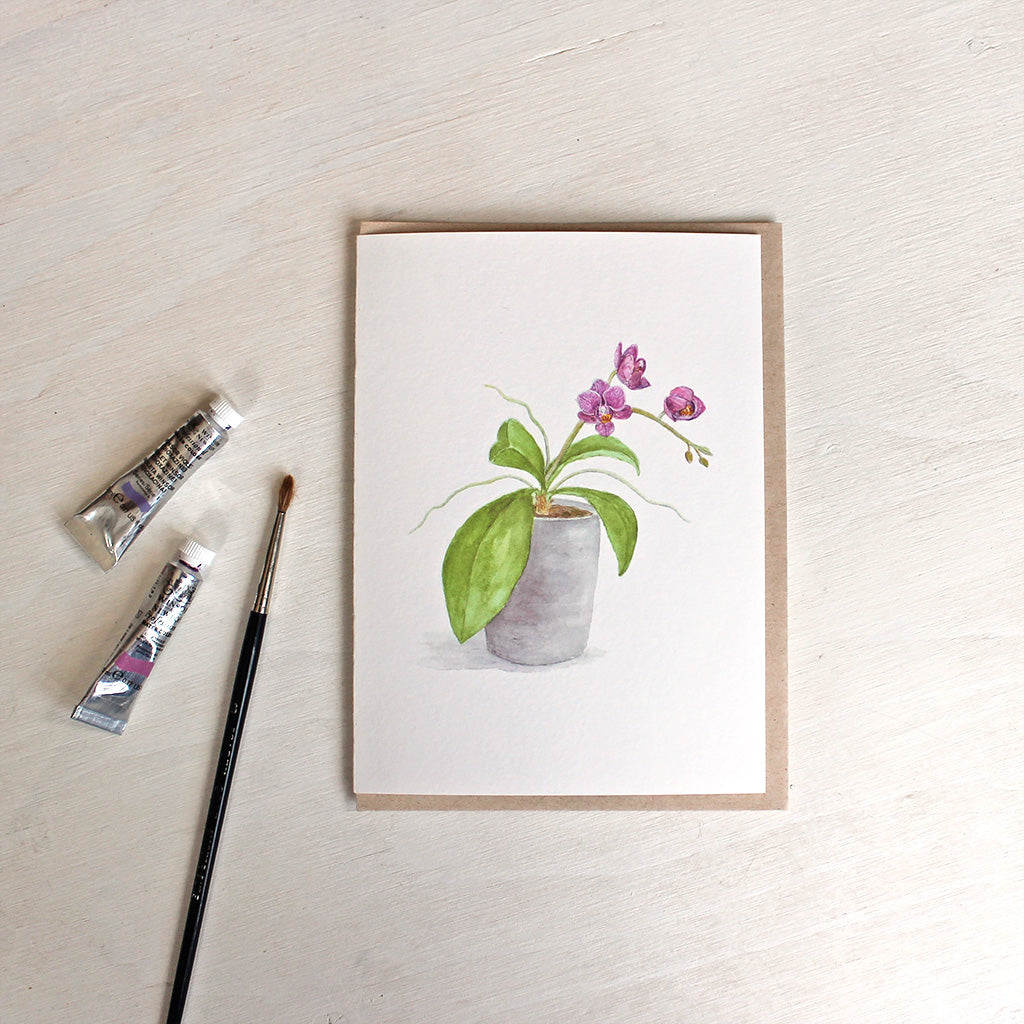 Note card and kraft envelope. Card features a watercolour painting of a pot of tiny magenta orchids. Artist Kathleen Maunder.