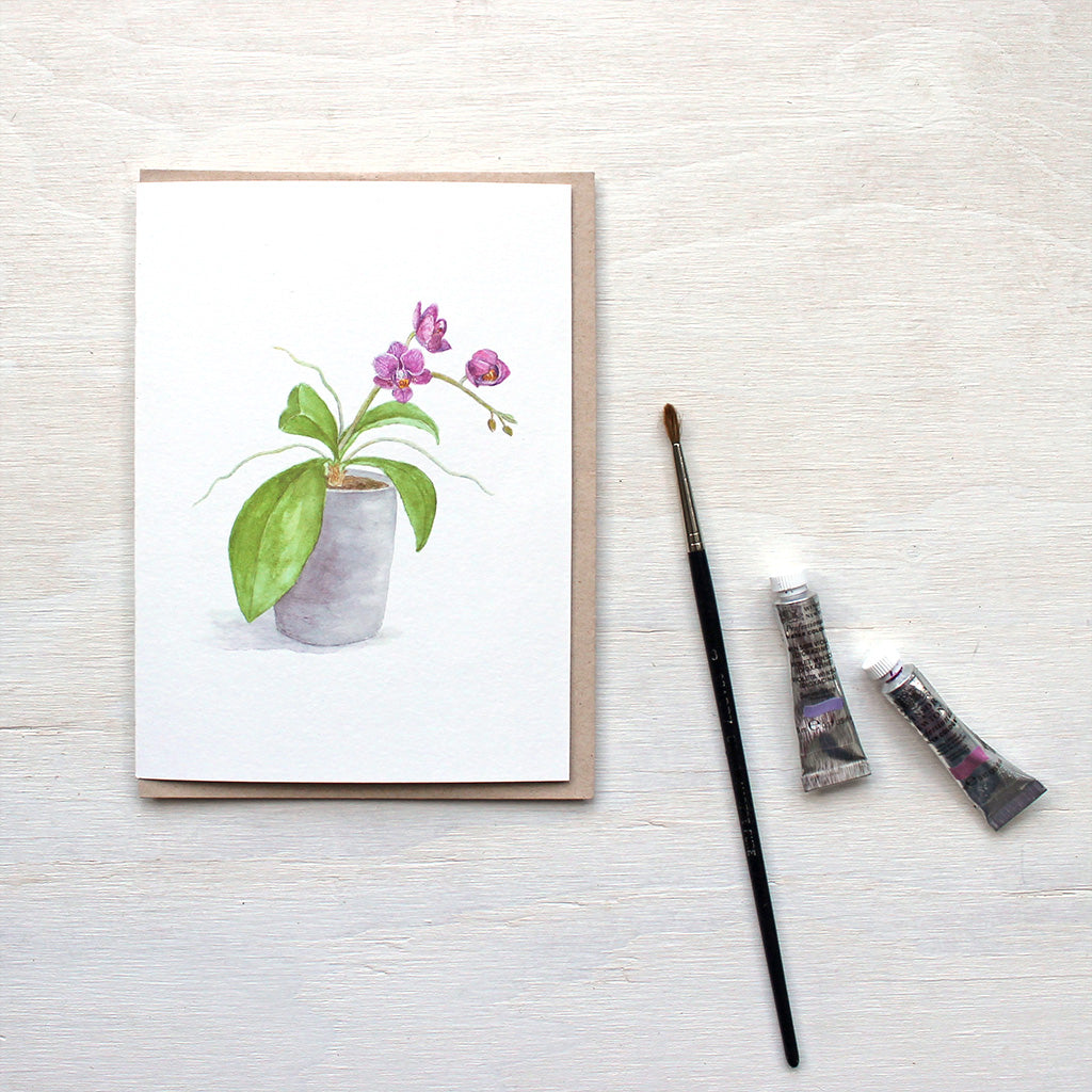 Note card featuring a watercolor painting of tiny magenta orchids. Artist Kathleen Maunder.