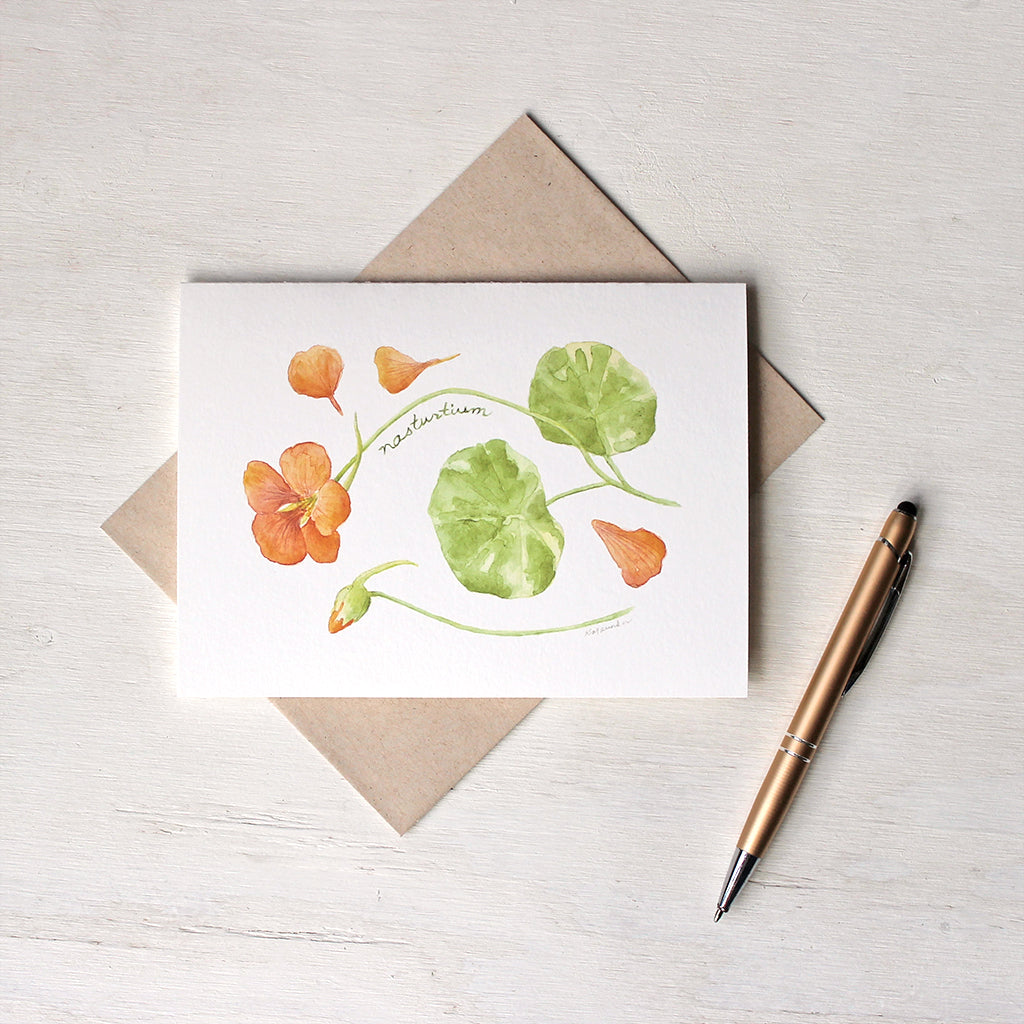 Note card featuring watercolour painting of orange nasturtium flower, petals, bud and leaves. Artist Kathleen Maunder.