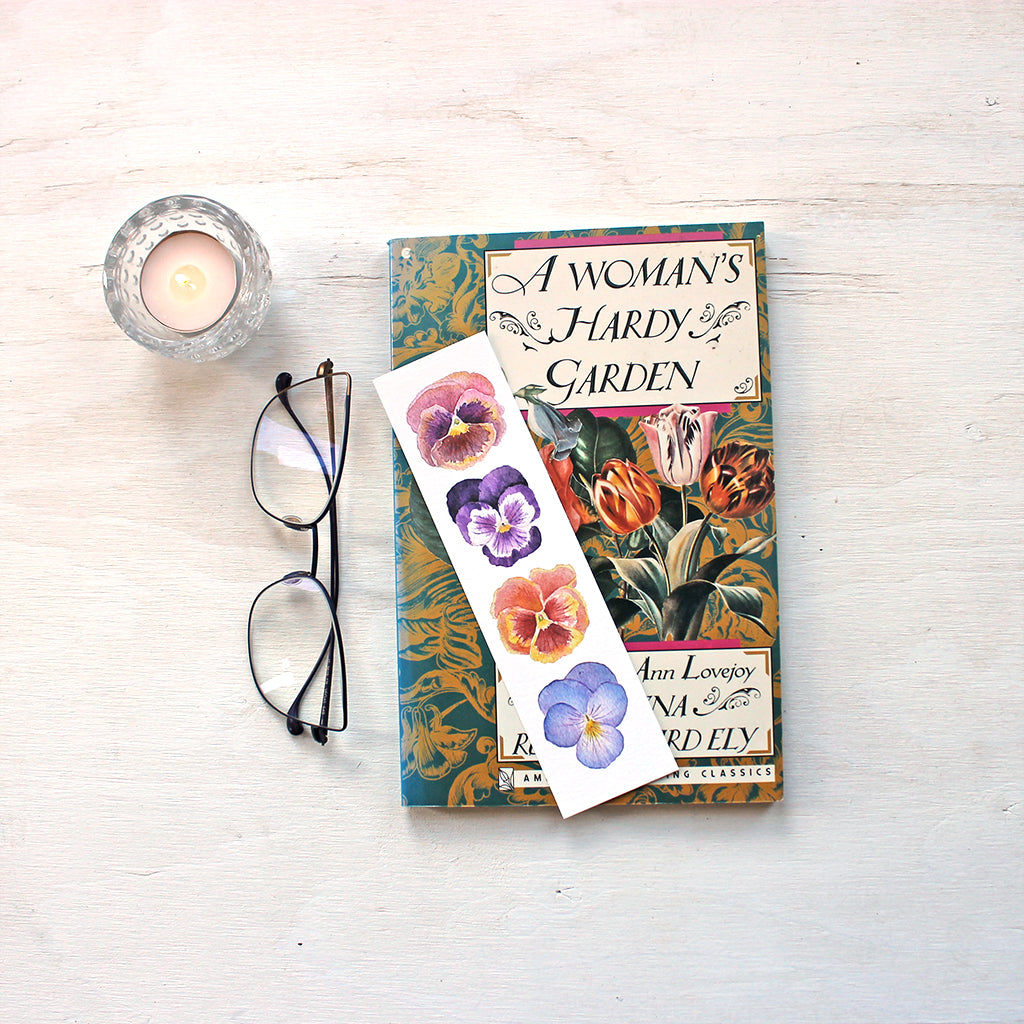 Bookmark featuring watercolor paintings of four pansies by artist Kathleen Maunder 