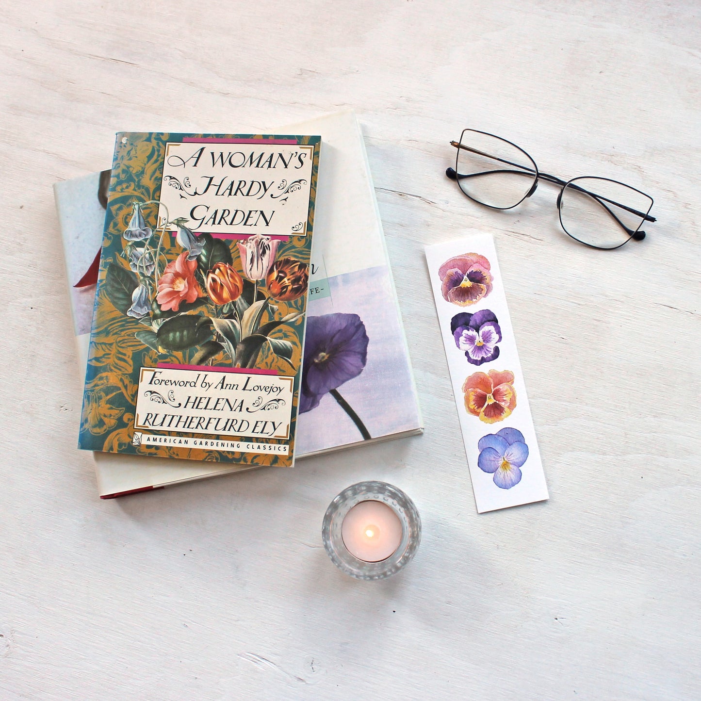 Paper bookmark featuring watercolor paintings of four pansies by Kathleen Maunder