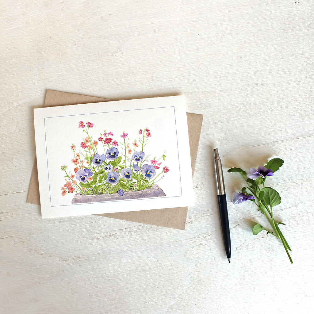 Note card featuring watercolor painting of purple-blue pansies, nemesia, diascia and euphorbia