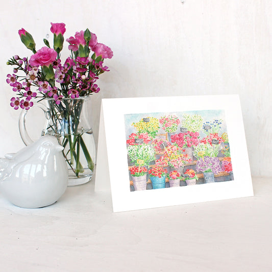 A note card featuring a watercolor painting of the flower market in Paris. Artist Kathleen Maunder