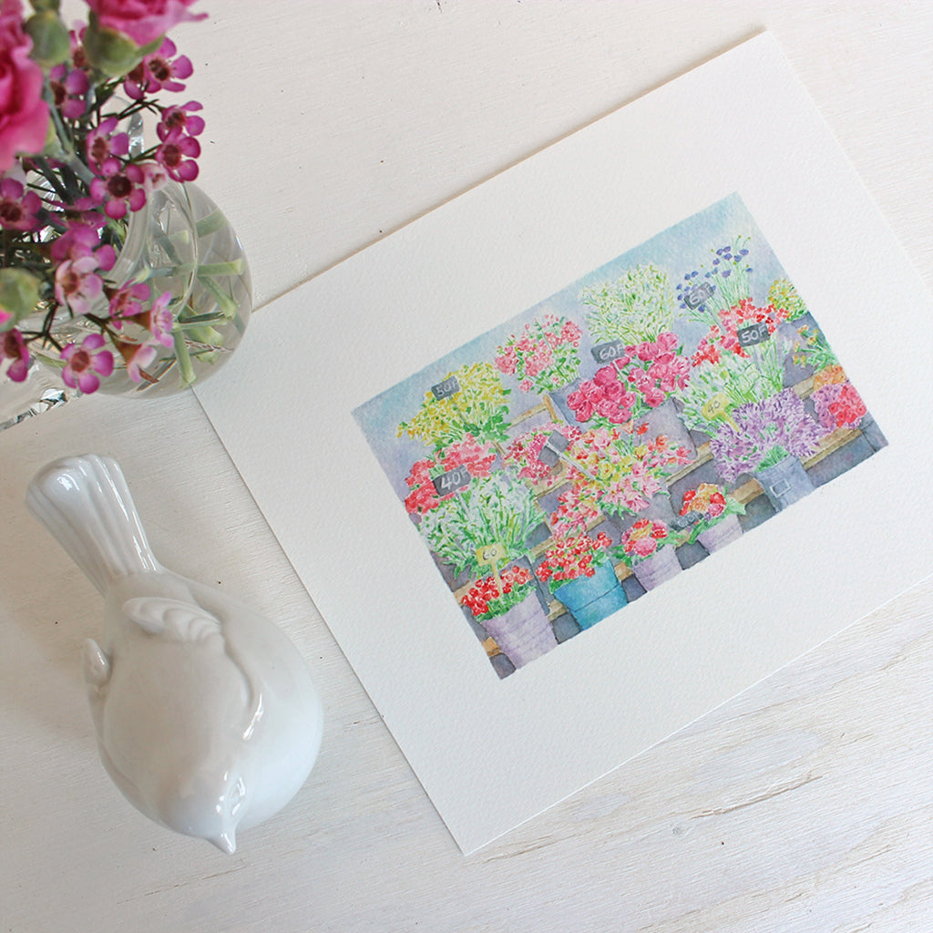 An art print featuring a beautiful watercolor painting of a flower stand at a Parisian flower market. Artist Kathleen Maunder.