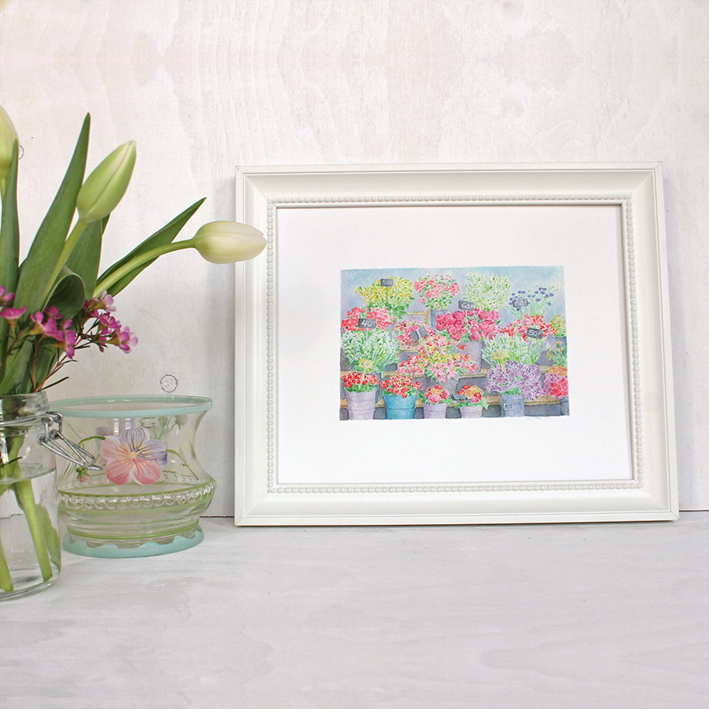 An art print featuring a beautiful watercolor painting of a flower stand at the Marché aux fleurs in Paris. Artist Kathleen Maunder.