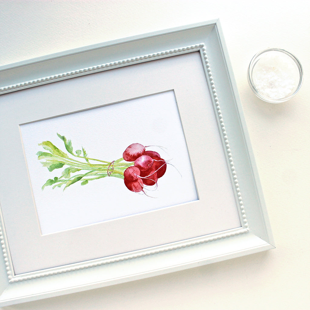 An art print featuring a lovely watercolor painting of a bunch of red radishes. (Shown framed.) Artist Kathleen Maunder.