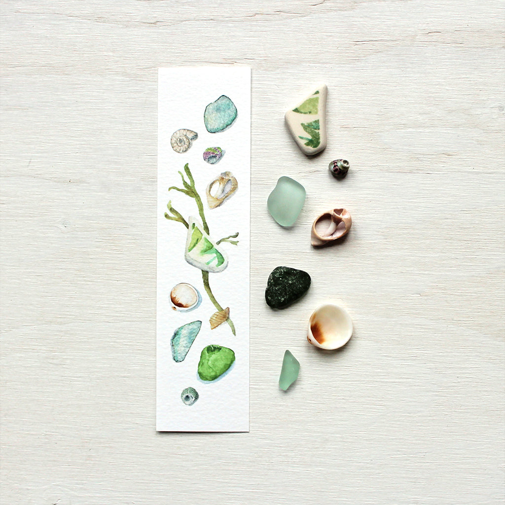 Paper bookmark with watercolor painting of beach finds (shells and sea glass)