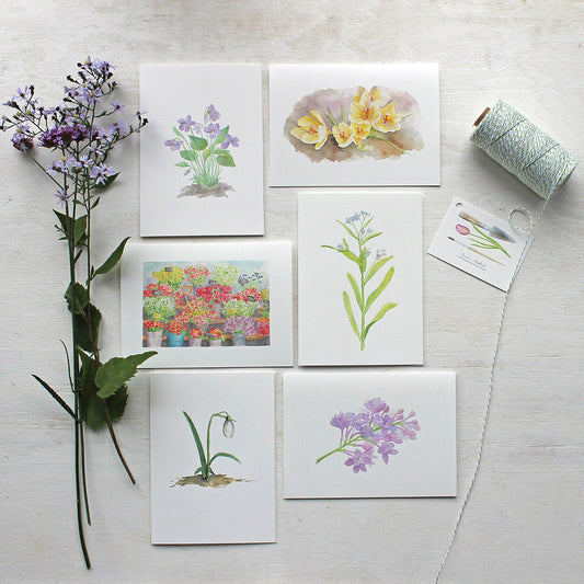 Set of six botanical note cards featuring flower watercolors by Kathleen Maunder. Includes images of violets, crocuses, forget-me-nots, lilacs, a snow drop and a Parisian flower market.