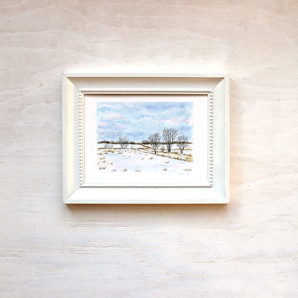 Framed print featuring a watercolor painting of snowy fields. Artist Kathleen Maunder.