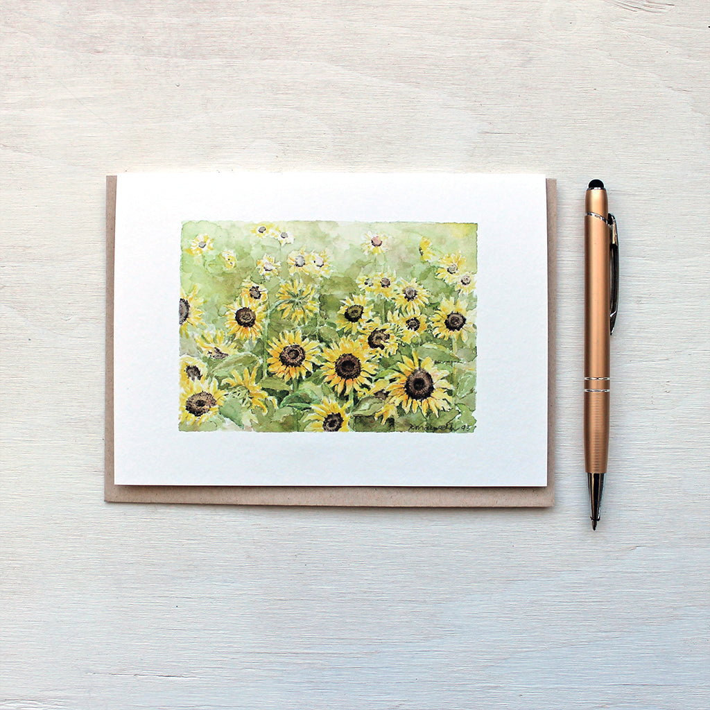 Note card featuring a watercolor painting of a sunflower field by Kathleen Maunder. Beautiful golds and greens.