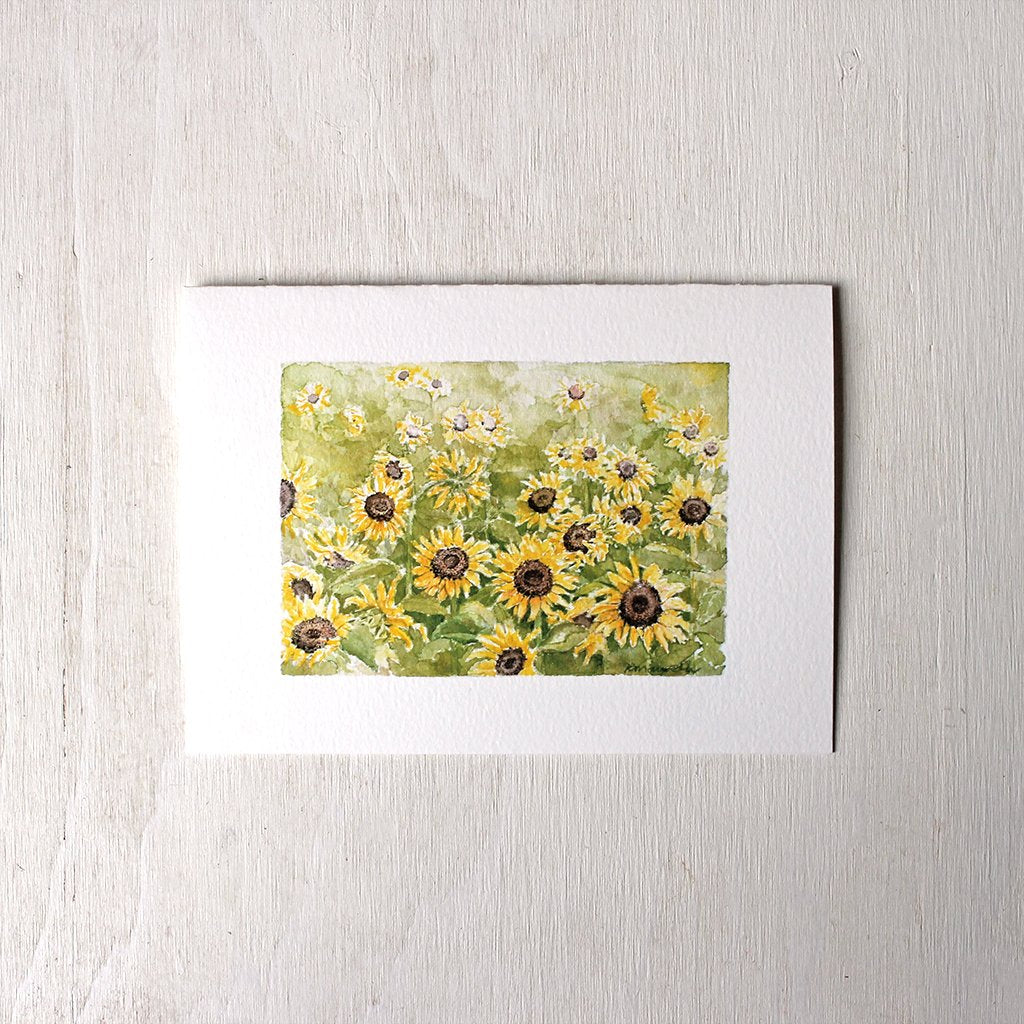 Note card featuring a watercolor painting of a cheerful sunflower field by Kathleen Maunder