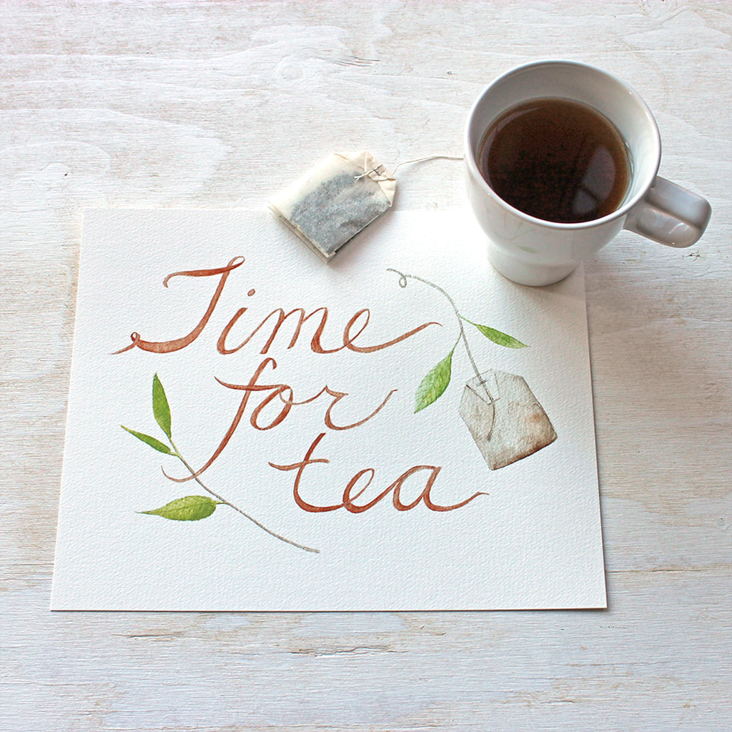 An art print featuring a lovely watercolor painting with the hand-lettered words 'Time for Tea', a tea bag and a sprig of a tea plant. Artist Kathleen Maunder.