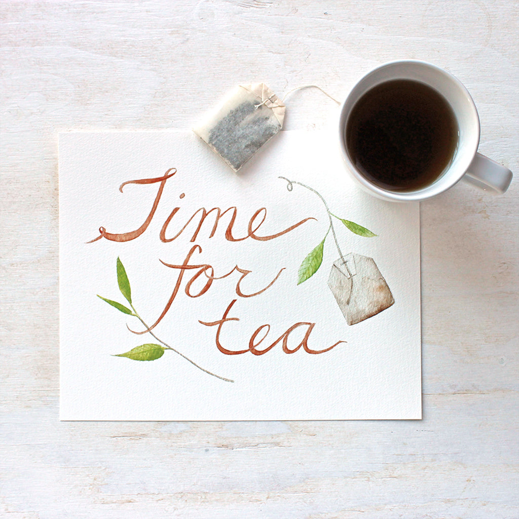 An art print featuring a lovely watercolor painting with the hand-lettered words 'Time for Tea', a tea bag and a sprig of a tea plant. Artist Kathleen Maunder.