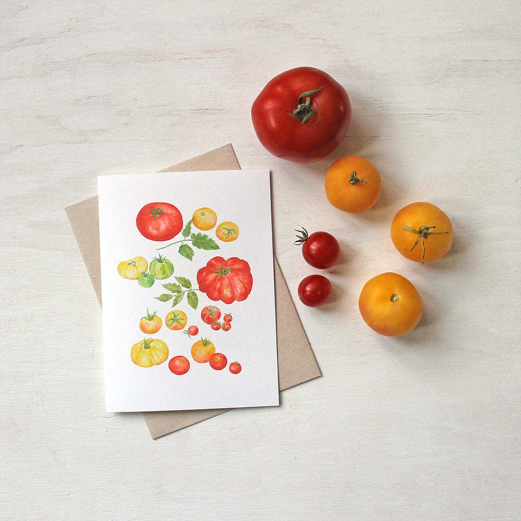 A note card showing several kinds of red, yellow and green heirloom tomatoes by watercolor artist Kathleen Maunder.