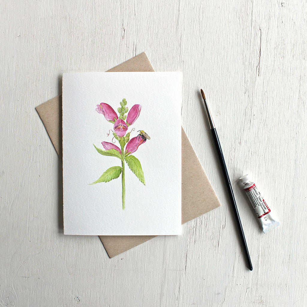 Pink Chelone obliqua flower and a bee on a note card by watercolour artist Kathleen Maunder.