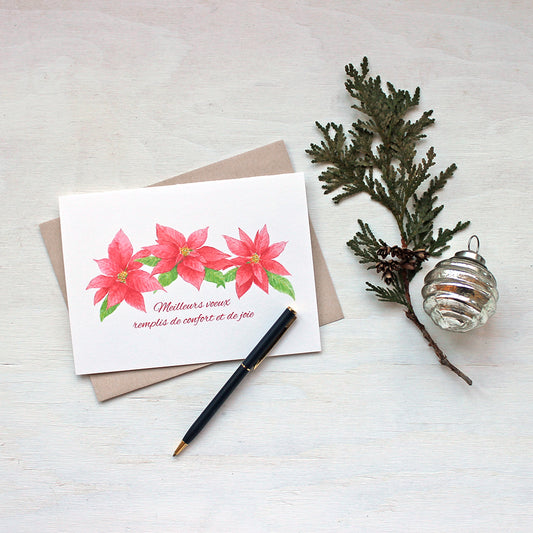 Carte de souhaits avec trois poinsettias rouges. Peinture à l'aquarelle par Kathleen Maunder.