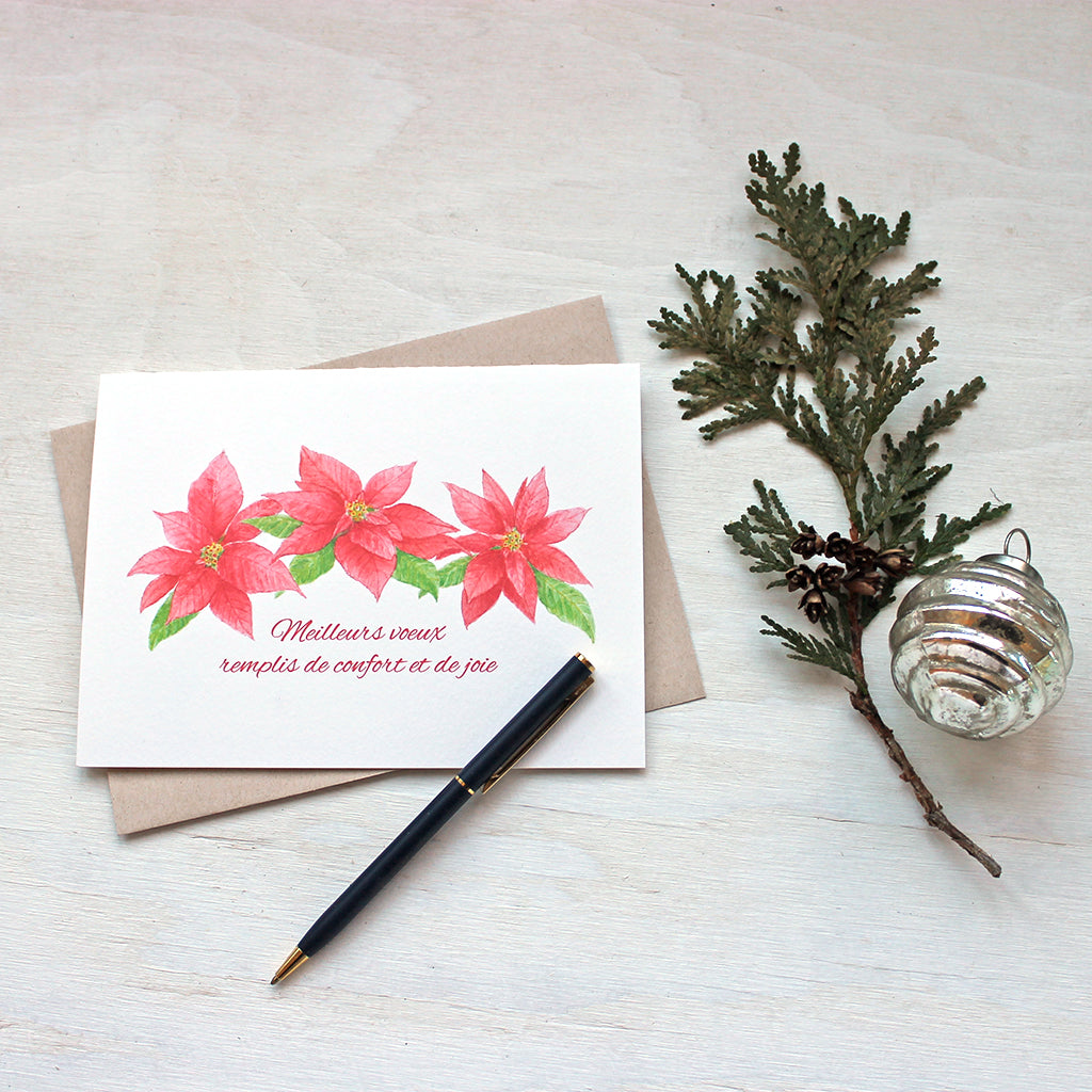 Carte de Noël avec trois poinsettias rouges. Peinture à l'aquarelle par Kathleen Maunder.