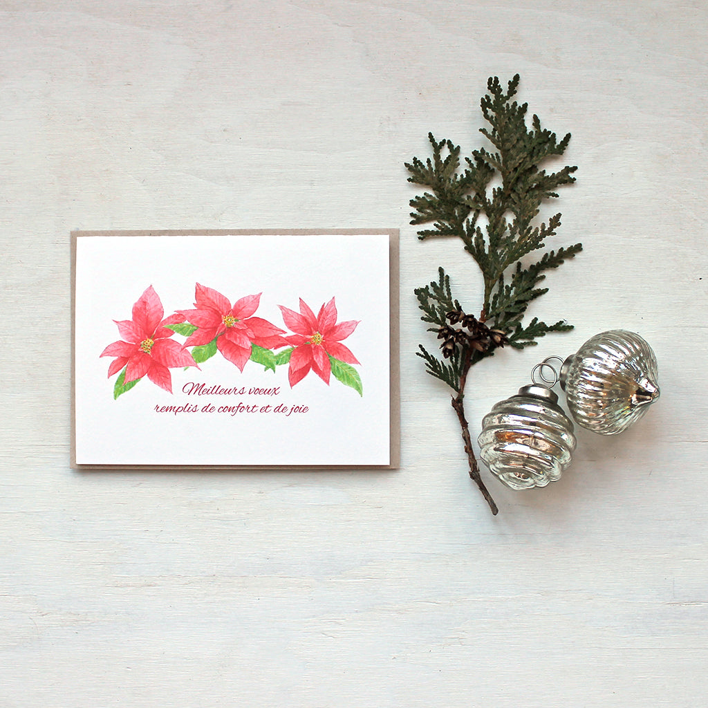 Carte de voeux avec trois poinsettias rouges. Peinture à l'aquarelle par Kathleen Maunder.