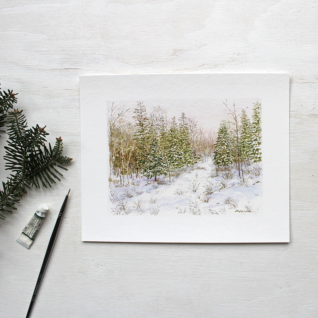 Winter Forest Print featuring a peaceful watercolor painting of a snowy forest by Kathleen Maunder